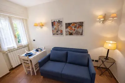 a living room with a blue couch and a table at èROMA - AVENTINO Apartment in Rome