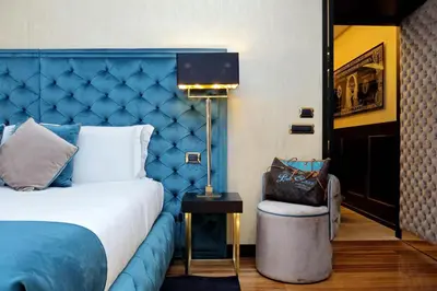 a bedroom with a blue bed and a chair at Spanish Gold Edition in Rome