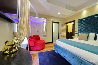 a hotel room with a bed and a red chair at Spanish Gold Edition in Rome