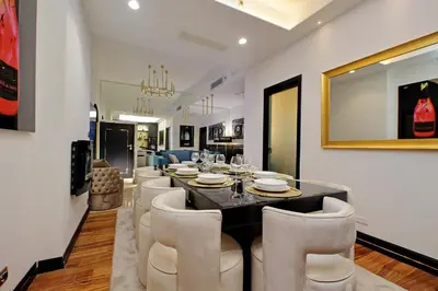 a dining room with a black table and white chairs at Spanish Gold Edition in Rome