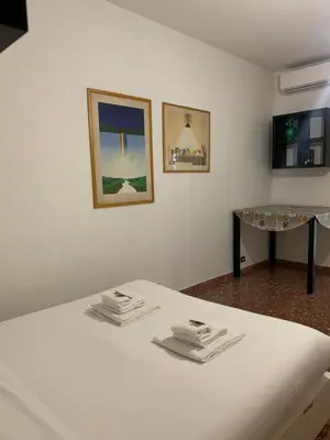 a white bed with two piles of towels on it at Valerie house Garbatella in Rome