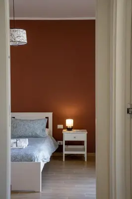 a bedroom with a bed and a table with a lamp at Little Red Apartment in Rome