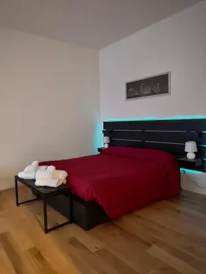 a bedroom with a bed with a red blanket and a table at Caesar's Suite Trastevere in Rome
