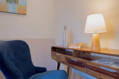 a desk with a blue chair and a lamp at Suite Castelfidardo 50 in Rome