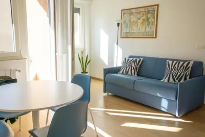 a living room with a blue couch and a table at Little Blue Apartment in Rome
