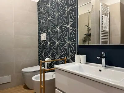 a bathroom with a sink and a toilet and a mirror at Little Blue Apartment in Rome