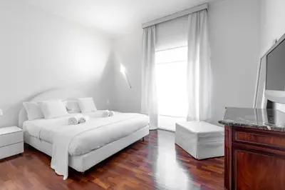 a white bedroom with a white bed and a television at Luxury White in Rome