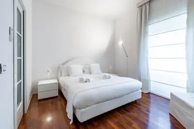 a white bedroom with a white bed and a large window at Luxury White in Rome