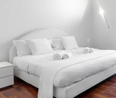 a white bed with two towels on top of it at Luxury White in Rome