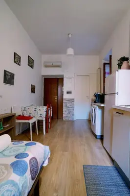 a room with two beds and a kitchen with a refrigerator at La casa dell’attore - Roma Pigneto in Rome