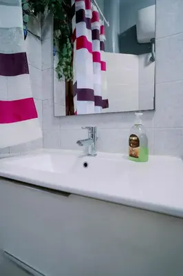 a bathroom sink with a mirror and a soap bottle on it at La casa dell’attore - Roma Pigneto in Rome