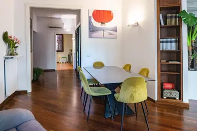 a dining room with a table and yellow chairs at Navona Luxury Flat in Rome