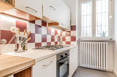 a kitchen with red and white tiles on the wall at Trastevere Holiday in Rome