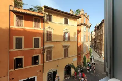 a group of people walking down a street with buildings at Giulia Charme - My Extra Home in Rome