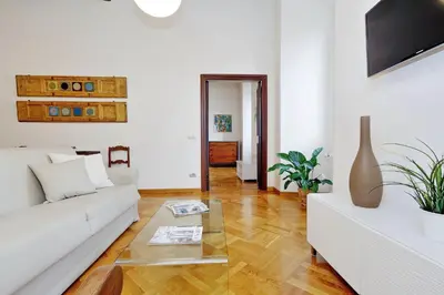 a living room with a white couch and a table at Giulia Charme - My Extra Home in Rome