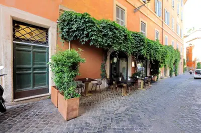 a building with tables and chairs on a street at Giulia Charme - My Extra Home in Rome