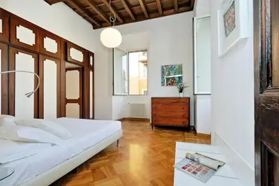 a bedroom with a white bed and a wooden floor at Giulia Charme - My Extra Home in Rome