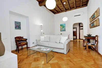 a living room with a white couch and a table at Giulia Charme - My Extra Home in Rome