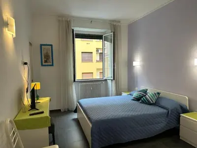 a bedroom with a blue bed and a window at Profumo di Sorrento a Roma in Rome