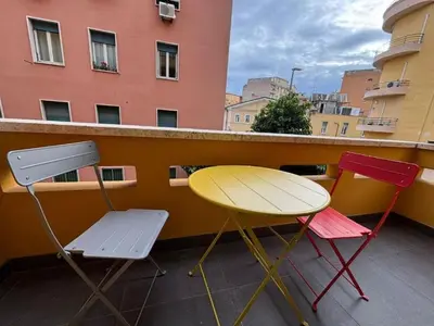 three chairs and a yellow table on a balcony at Profumo di Sorrento a Roma in Rome