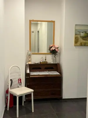 a bathroom with a vanity with a mirror and a chair at Profumo di Sorrento a Roma in Rome