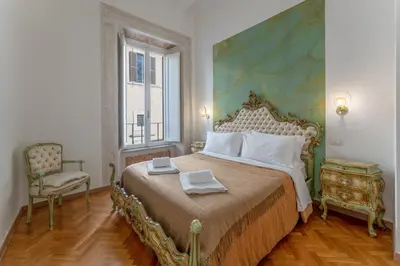 a bedroom with a large bed and a chair at Palazzo Pamphili Apartment in Rome