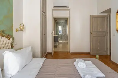 a bedroom with a bed and a hallway at Palazzo Pamphili Apartment in Rome