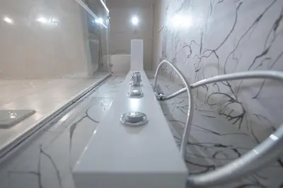 a white bench in a bathroom with a marble wall at Palazzo Pamphili Apartment in Rome