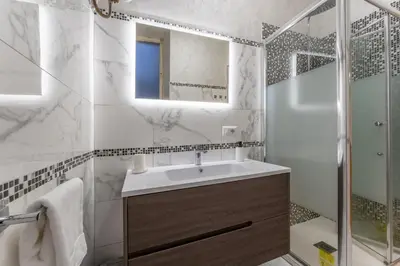 a bathroom with a sink and a shower and a mirror at Palazzo Pamphili Apartment in Rome