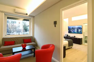 a living room with a couch and red chairs at Roma Centro CDR Luxury Suites in Rome