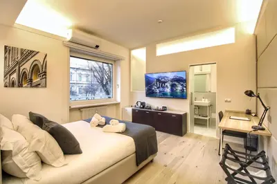 a bedroom with a bed and a desk and a window at Roma Centro CDR Luxury Suites in Rome