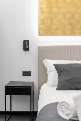a bedroom with a bed and a night stand next to a table at Roma Centro CDR Luxury Suites in Rome