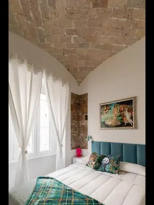 a bedroom with a large bed and a brick wall at Bretone XI b&b in Rome