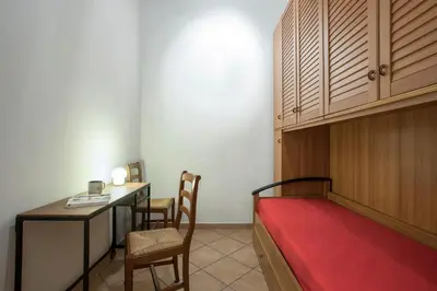 a room with a bed and a desk and a table at Castro Pretorio Cozy apartment in Rome