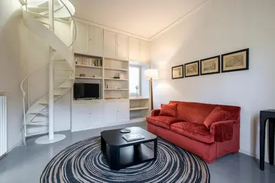 a living room with a red couch and a table at Colosseo Esclusivo attico con terrazze private in Rome