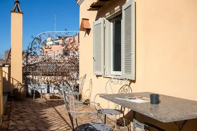 a patio with a table and chairs on a balcony at Colosseo Esclusivo attico con terrazze private in Rome