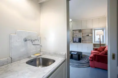 a kitchen with a sink and a living room at Colosseo Esclusivo attico con terrazze private in Rome