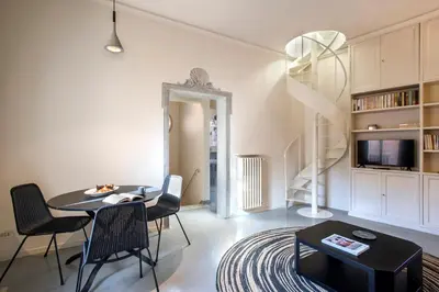 a living room with a table and chairs and a television at Colosseo Esclusivo attico con terrazze private in Rome