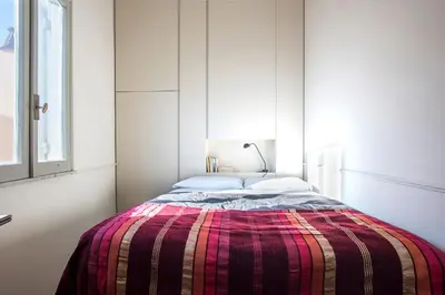 a bedroom with a bed with a plaid blanket at Colosseo Esclusivo attico con terrazze private in Rome