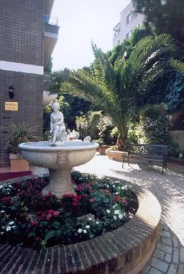 a fountain with a statue in a courtyard with flowers at Family Suite in Rome