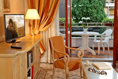 a living room with a television and a table with a dining room at Family Suite in Rome