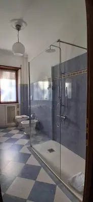 a bathroom with a glass shower and a toilet at Family Suite in Rome