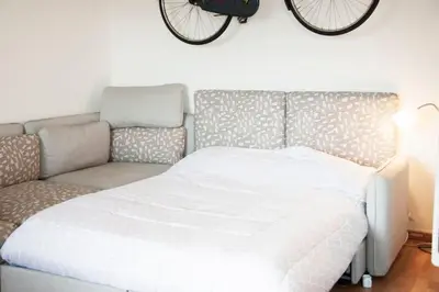 a bed and a couch in a room with a bike on the wall at Mickey's House in Rome