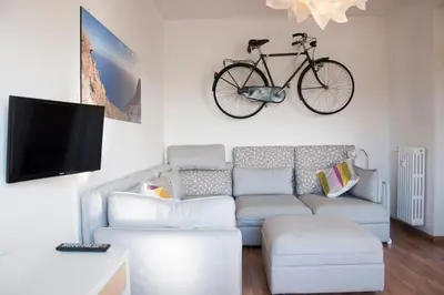 a living room with a couch and a bike hanging on the wall at Mickey's House in Rome