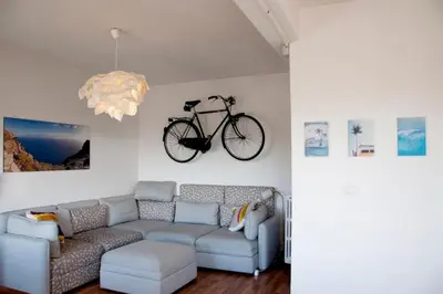 a living room with a couch and a bike on the wall at Mickey's House in Rome