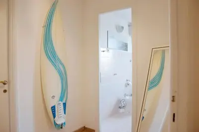 a bathroom with a surfboard hanging on the wall at Mickey's House in Rome