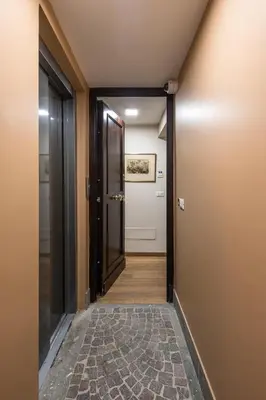 an open hallway with a door and a rug at La Gatta De Lisa in Rome