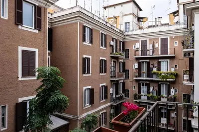 an apartment building with pink flowers in a balcony at Via G. Ferrari Private Apartment in Rome