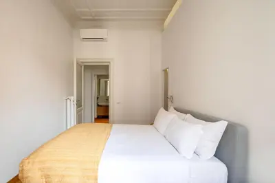 a bedroom with a bed with white sheets and pillows at Via G. Ferrari Private Apartment in Rome