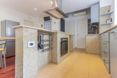 a kitchen with a tiled wall with a stove at Family Art Flat in Rome